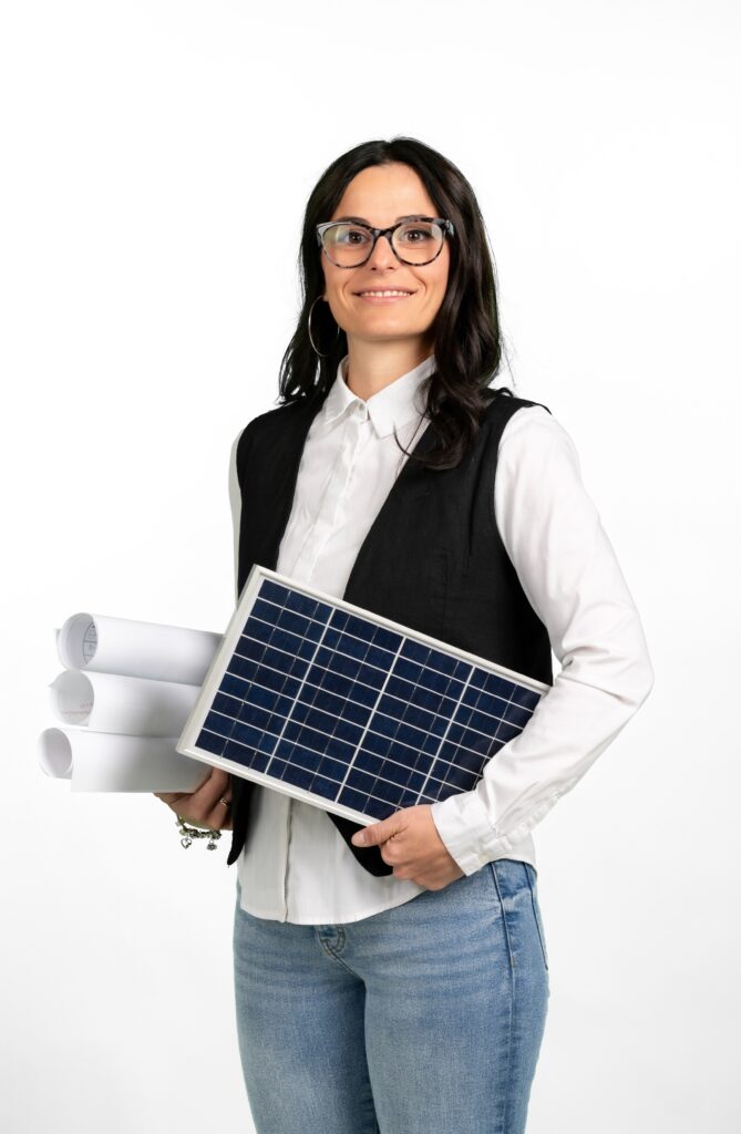 Serena Russello, socia fondatrice di Enerteam, responsabile dell'area tecnica, con un pannello fotovoltaico e i progetti di un impianto